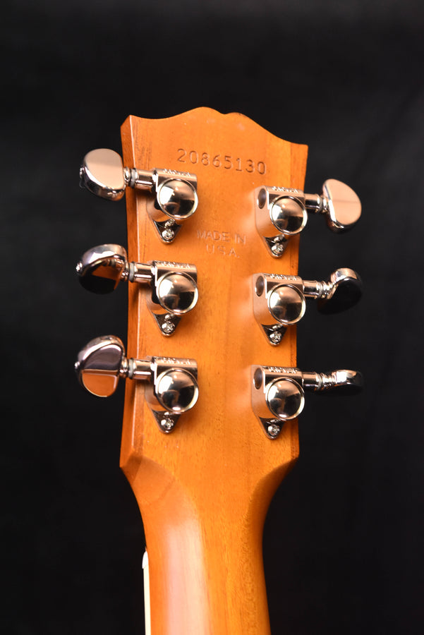 Orange guitar headstock front with chrome tuning machines and stamped serial number