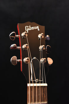 natural guitar headstock with gibson logo and six tuning pegs