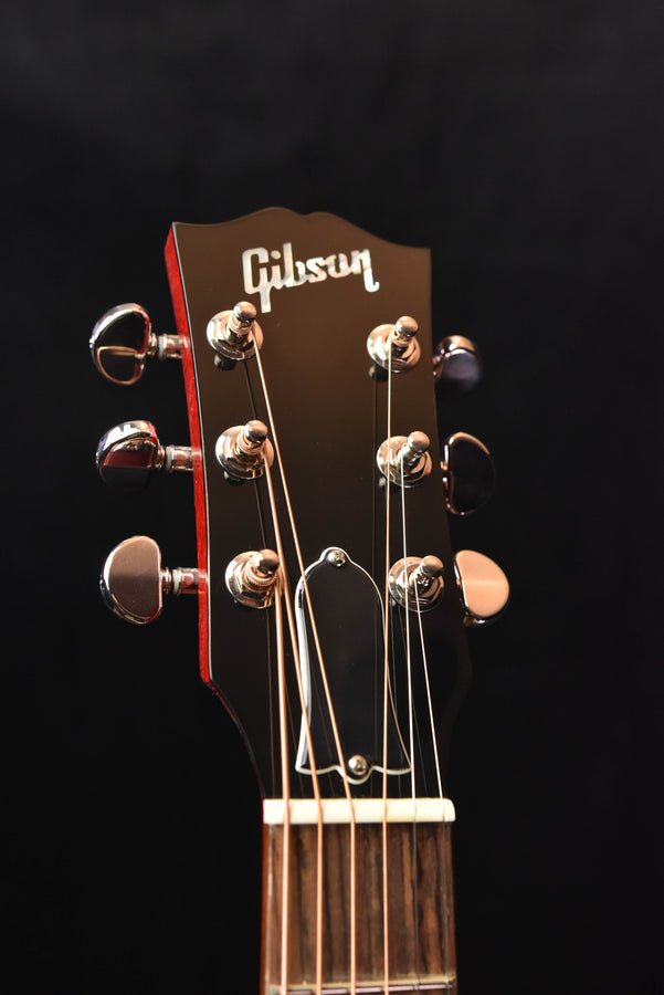 Natural guitar headstock with Gibson logo and six tuning pegs