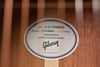 Guitar label plate with Gibson-style text on light wood body