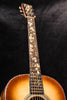 Acoustic guitar headstock with gold tuning pegs and bound fretboard