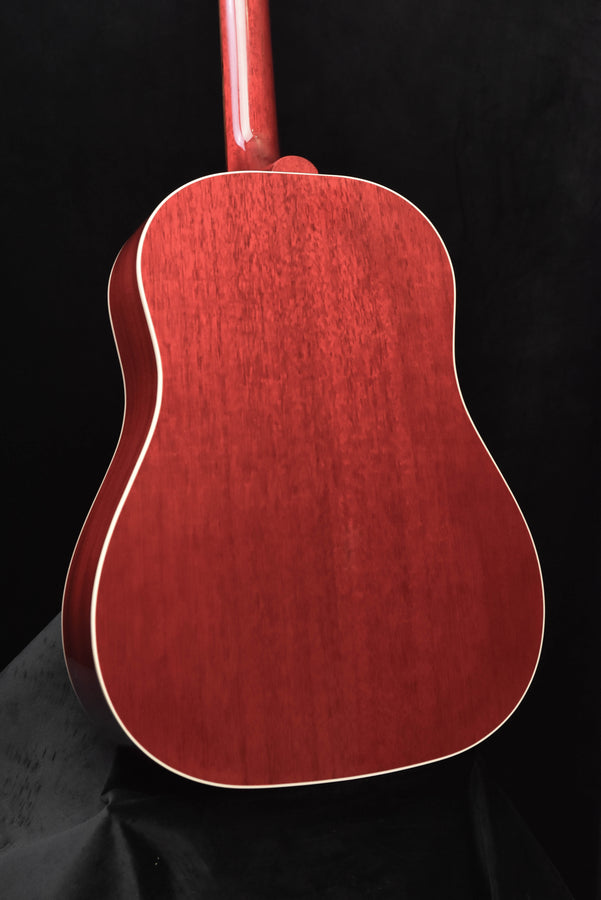 Red acoustic guitar front view with curved body and cream binding