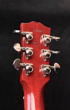 red guitar headstock with tuning hardware and stamped number text