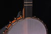 Banjo neck and strings above grey resonator head with wooden rim