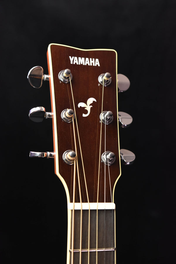 Acoustic guitar headstock with tuning pegs and Yamaha logo visible