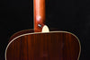 Acoustic guitar top near neck joint, cream pickguard and bridge area visible