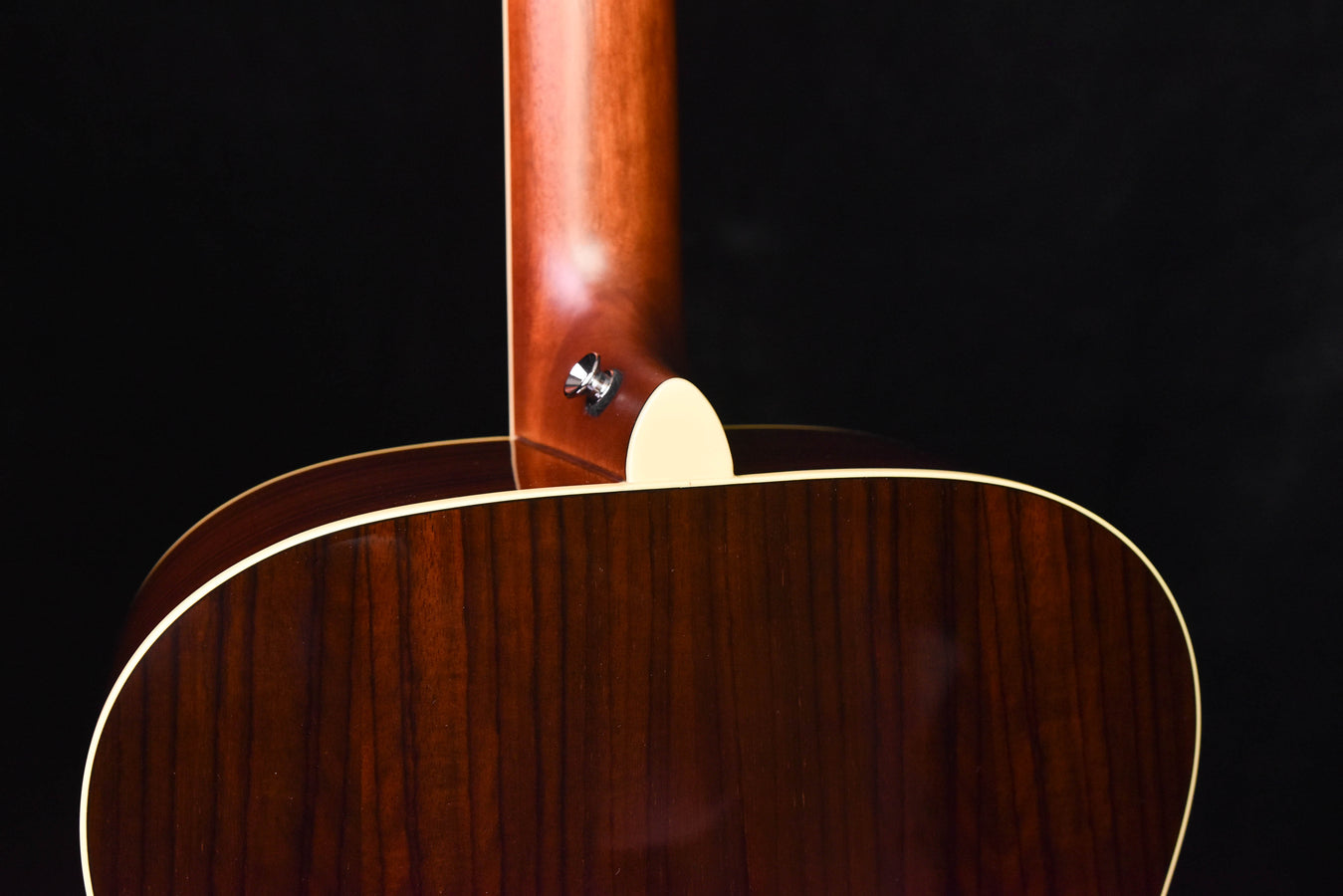 Acoustic guitar top near neck joint, cream pickguard and bridge area visible