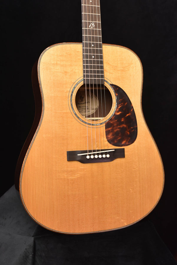 Acoustic dreadnought guitar, close front view: sound hole rosette and bridge area