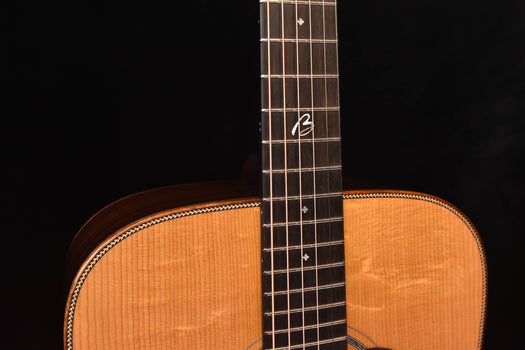 acoustic guitar neck and fretboard with dot inlays and decorative headstock logo