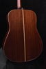 Acoustic guitar back view with dark wood grain and decorative binding along edges