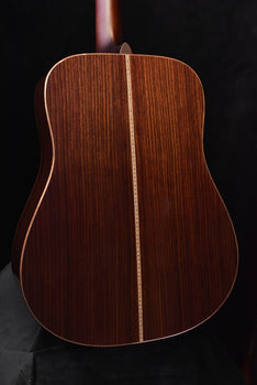 acoustic guitar back view with dark wood grain and decorative binding along edges