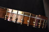 Banjo tuning pegs and strings with chrome hardware along the walnut neck