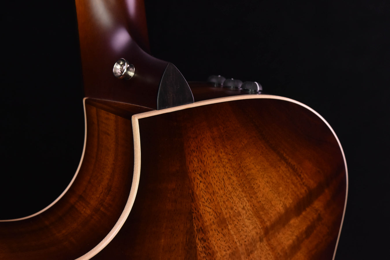 Koa guitar upper body with binding and soundhole area in warm brown tone