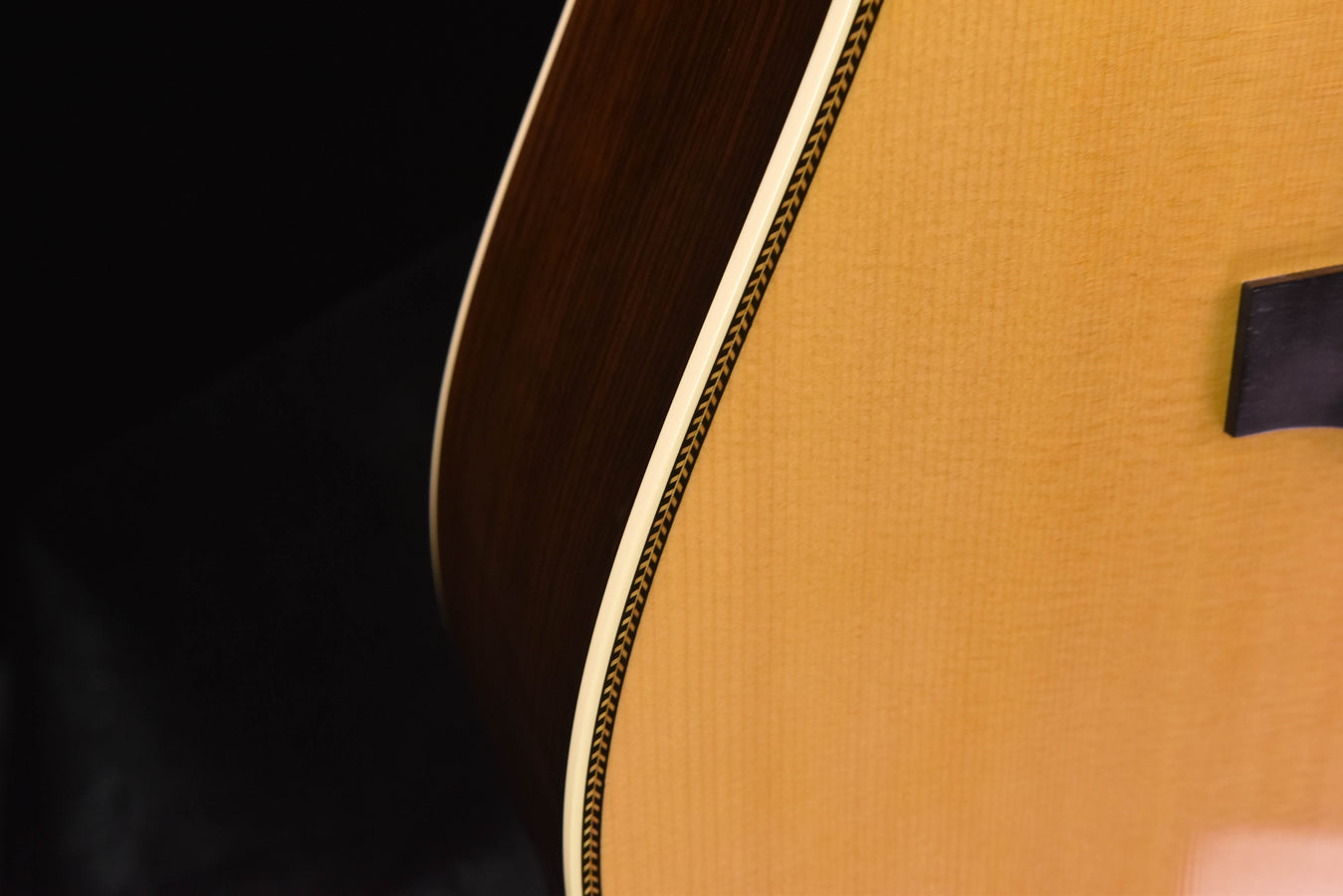 Acoustic guitar side view with decorative binding along the body edge