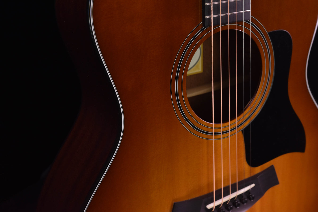 Taylor 316CE sunburst acoustic guitar close-up of soundhole, strings, and pickguard