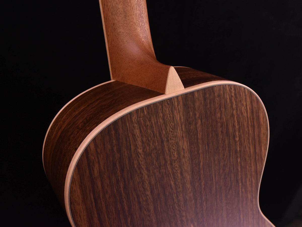 Custom guitar body edge with light binding and rich dark wood grain