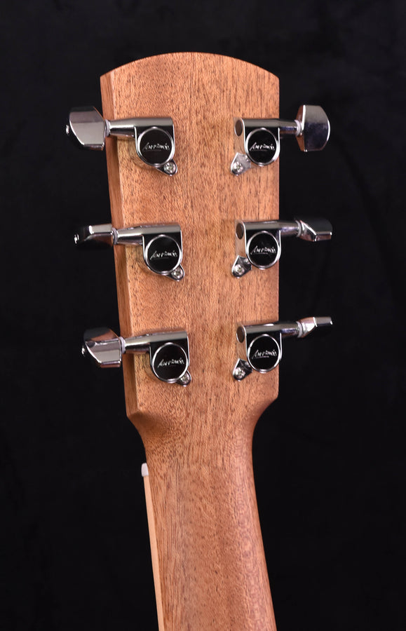 Guitar headstock with six chrome tuners on warm wood