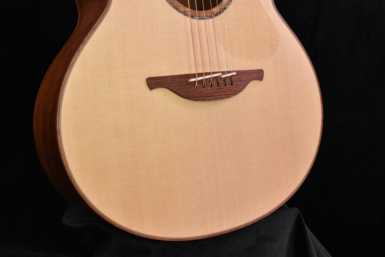 Lowden F50 guitar close-up of bridge, strings, and light wood soundboard