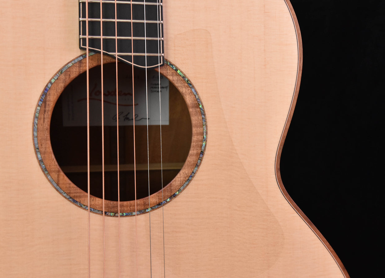 Lowden F50 soundhole close-up with dark rosette ring and strings over body