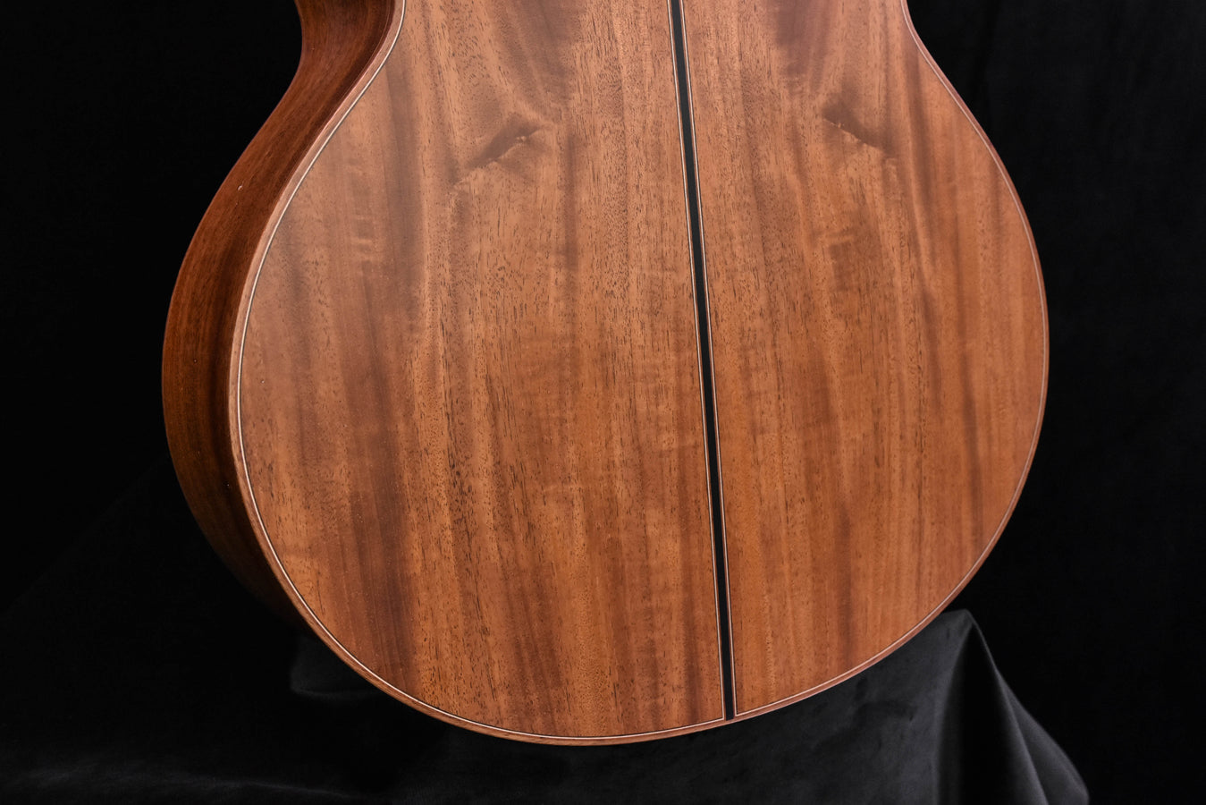 Acoustic guitar body with warm wood grain and light binding around edges