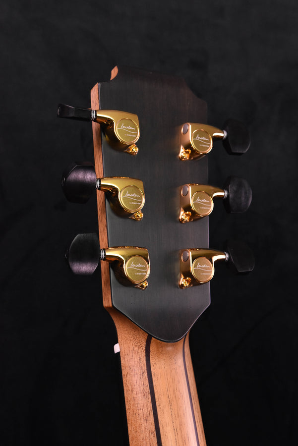 Guitar headstock front with six gold tuning machines and brand logo