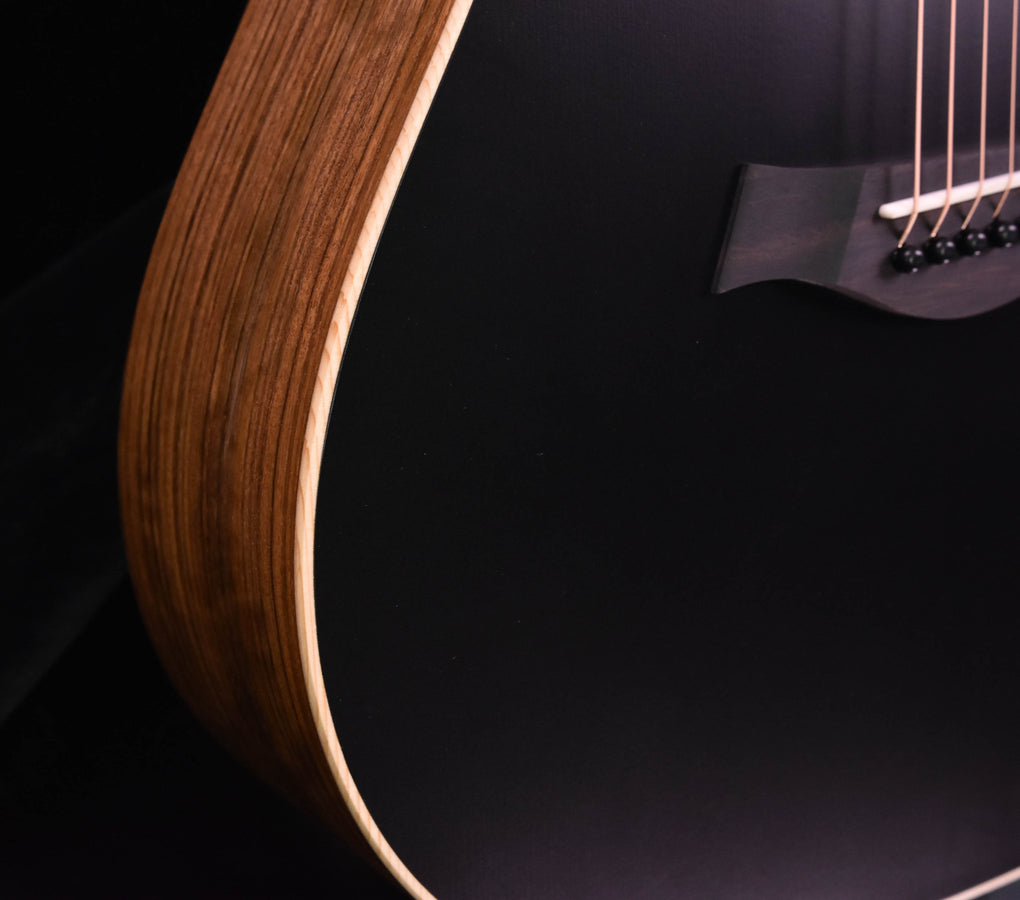 Blacktop guitar side view with wooden body edge and part of the neck