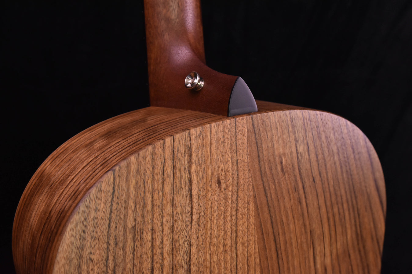 Blacktop guitar back near neck joint with glossy wood finish and tuner