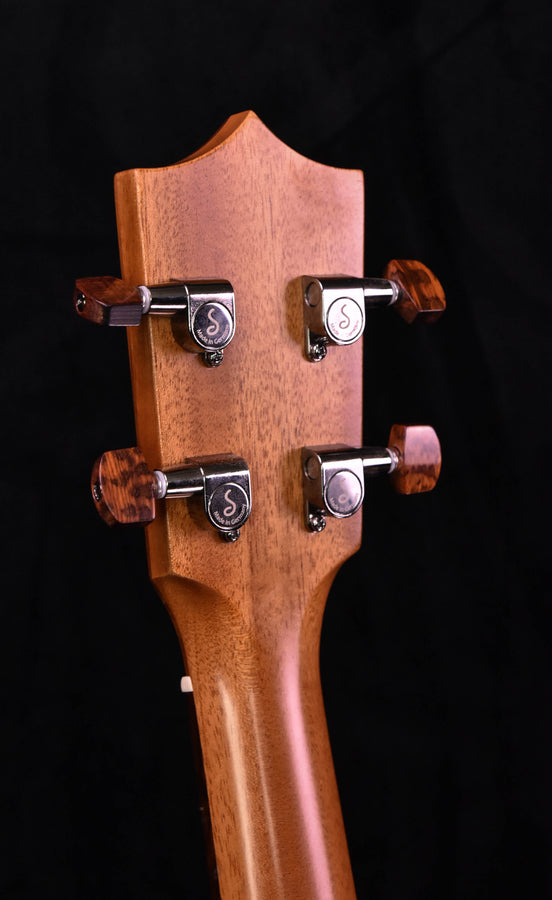 Ukulele headstock close-up with four tuning pegs in metal housings
