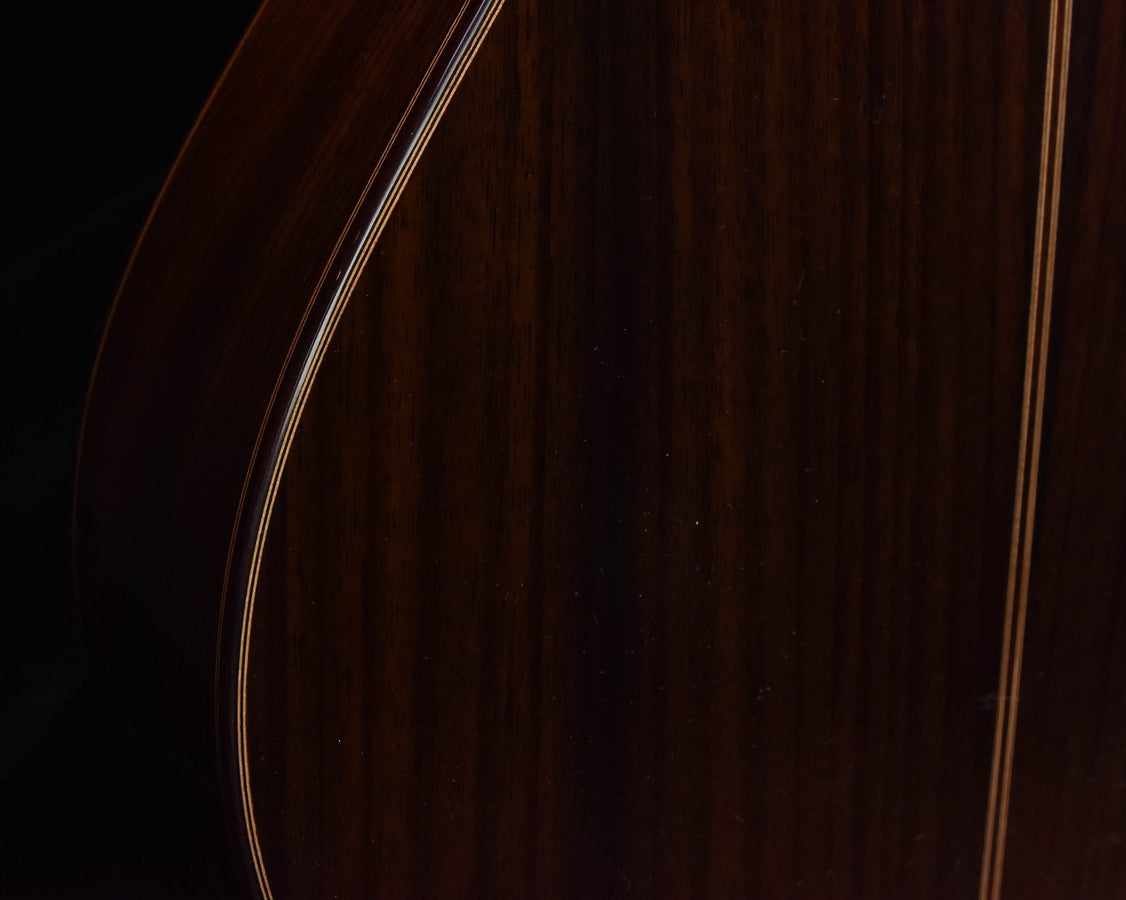 Classical guitar side with binding lines, close-up of dark wood body