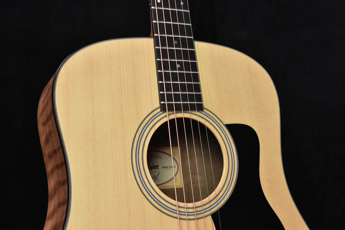 Acoustic sound hole with rosette rings and strings on natural guitar body