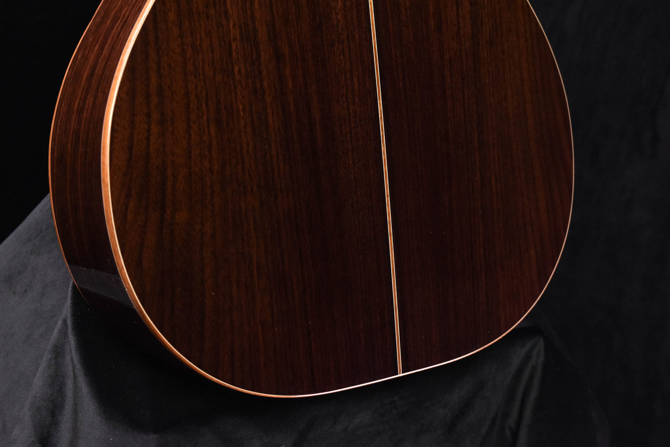 Acoustic guitar back panel close-up with binding and center seam