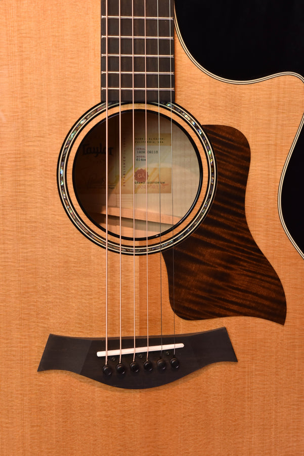 Close-up of acoustic guitar soundhole and black bridge with six strings