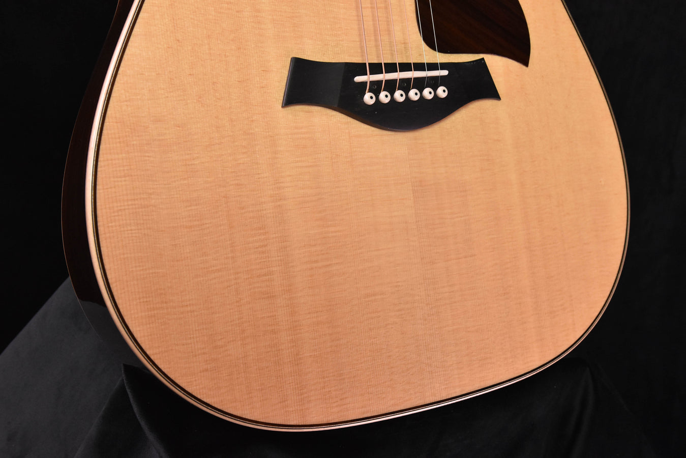 Used acoustic guitar front view: pickguard, bridge area, and smooth natural top