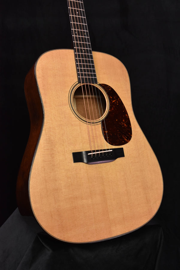 Dreadnought acoustic guitar close-up: light soundboard, dark teardrop pickguard area, rosette