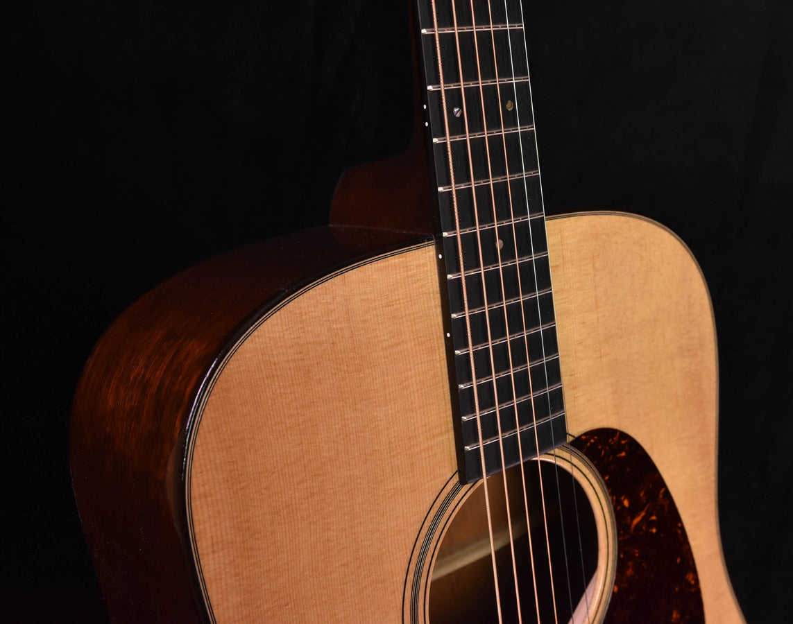 Dreadnought acoustic guitar neck and soundhole area with dark quilted finish around rosette