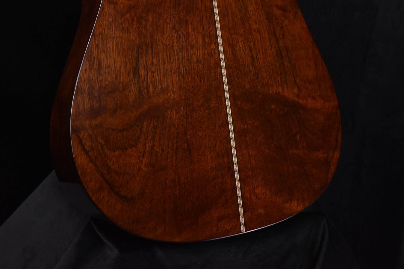 Quilt mahogany back panel with visible swirling grain and dark center seam