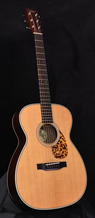 Acoustic guitar with light wood top, rosette sound hole, and black tortoiseshell pickguard