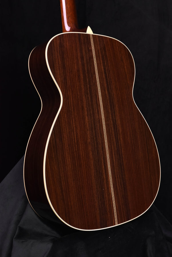 Acoustic guitar back close-up with dark wood grain and cream binding edge