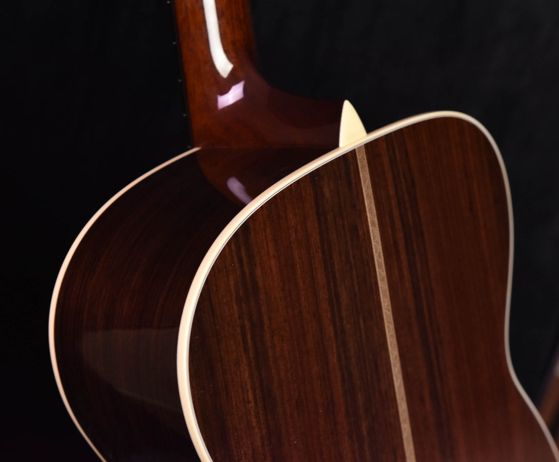 Acoustic guitar side and upper bout close-up with glossy dark wood finish