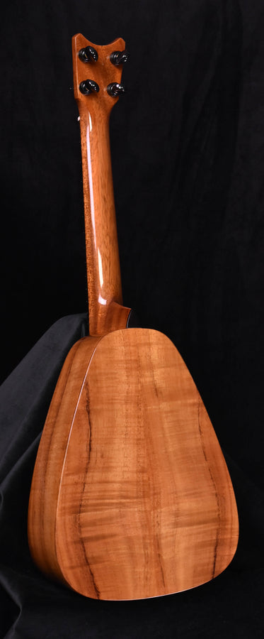 Koa tenor ukulele back view with smooth curved body and dark finish