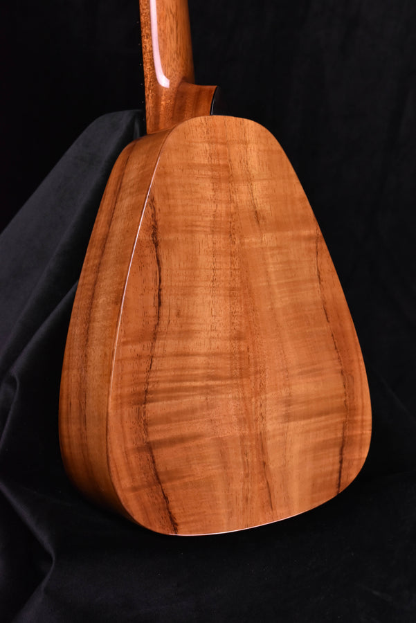 Koa tenor ukulele side view showing long neck and rounded body