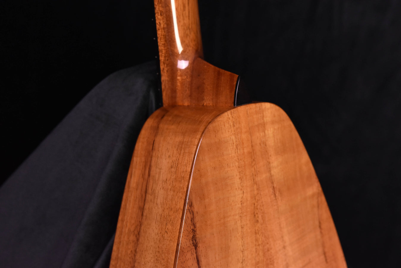 Koa tenor ukulele back and neck view with even wood tone and curve