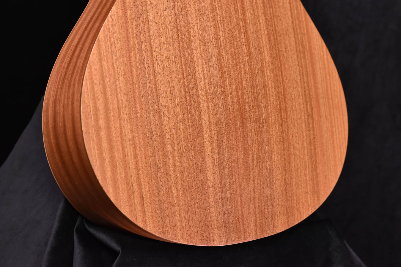 Acoustic guitar soundboard with natural wood grain and curved outline
