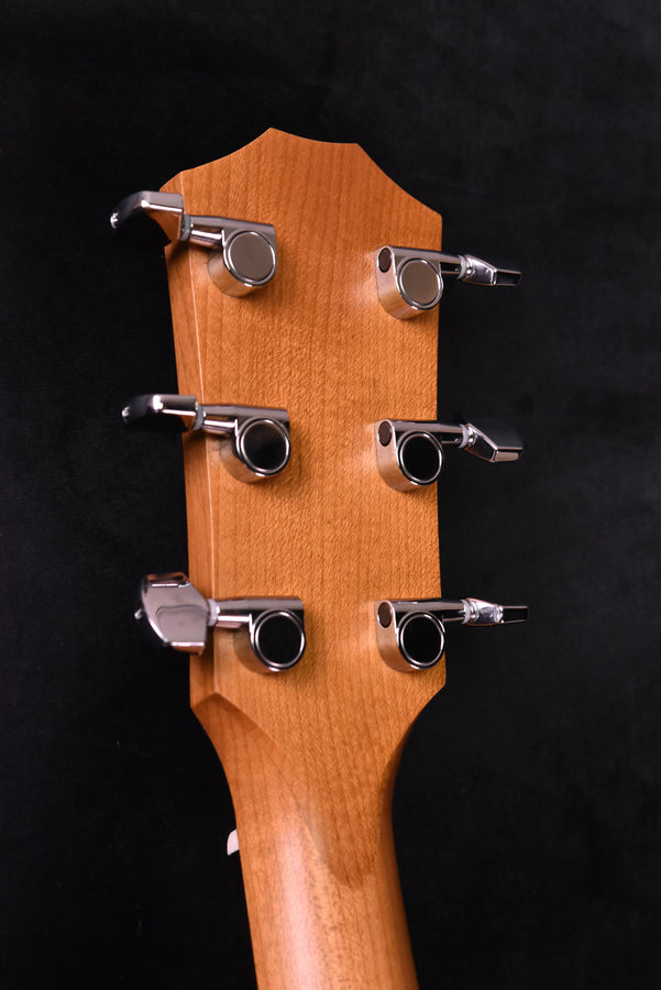Acoustic guitar headstock close-up with six silver tuning machines