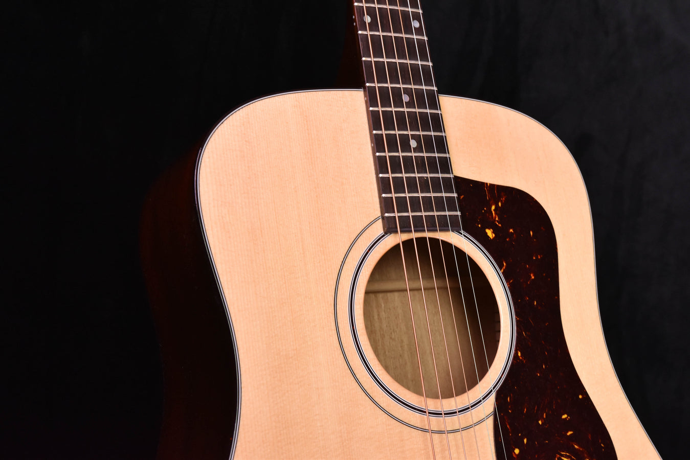 Natural-finish Guild D-40 acoustic guitar rosette and top surface close-up