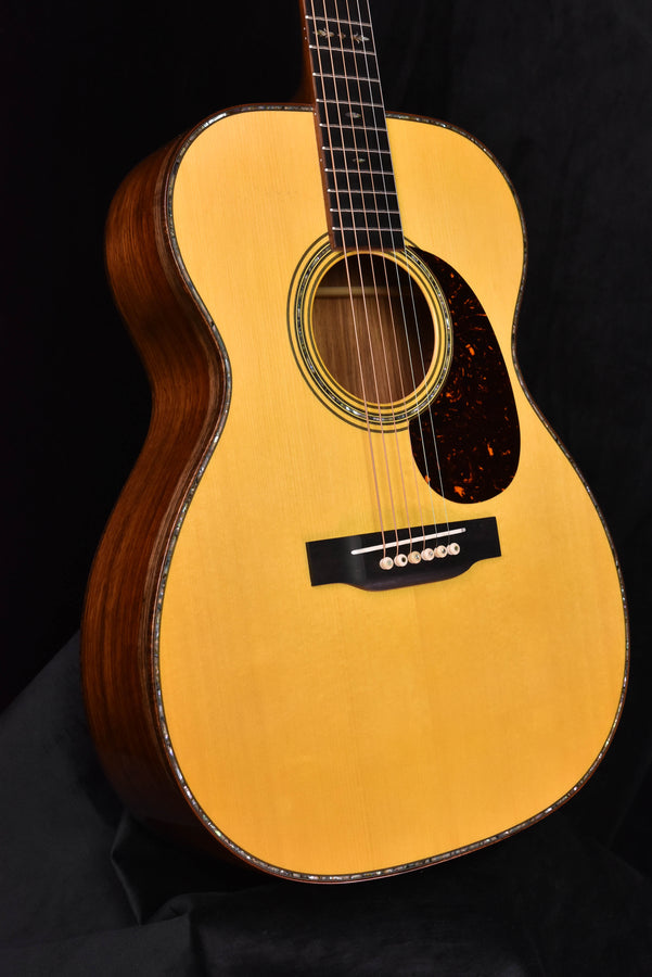 Acoustic guitar close view of sound hole with abalone-style rosette and dark pickguard