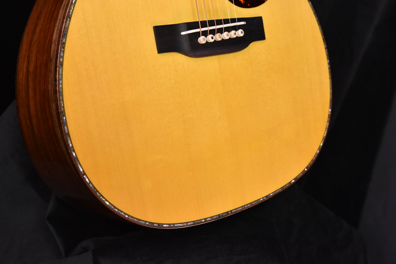 Acoustic guitar body front with smooth light finish and dark side binding around edges