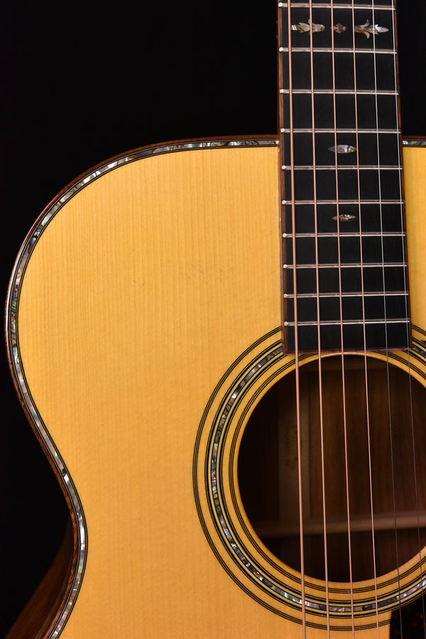 Acoustic guitar body and rosette detail with overlapping rings near the sound hole
