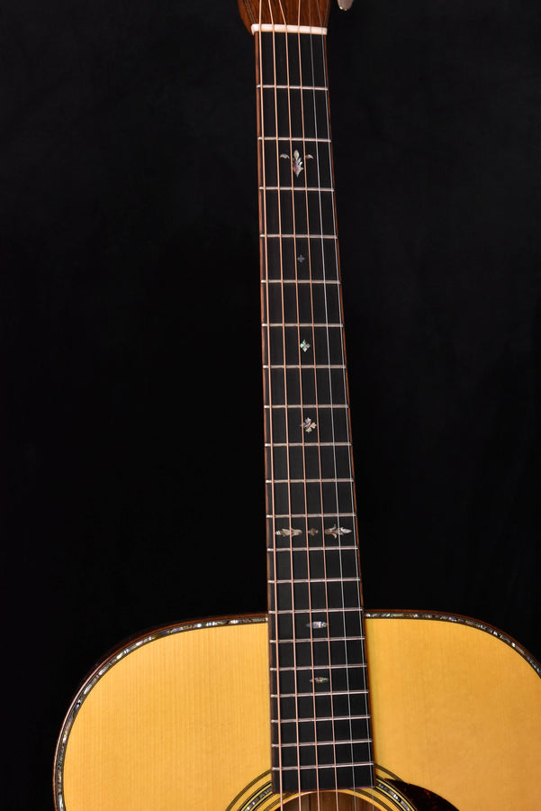 Acoustic guitar fretboard with dot inlays and frets extending to the body joint