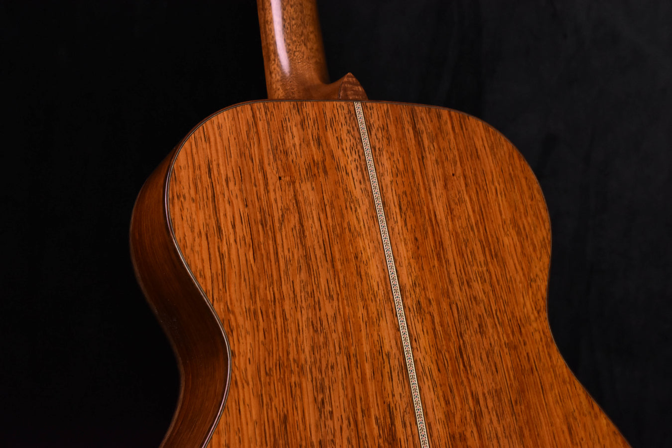 Acoustic guitar body front view with natural wood finish and center seam stripe